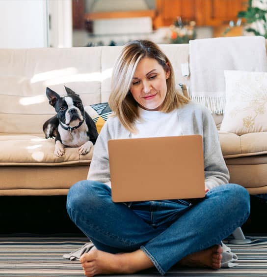 Woman on a laptop with a dog